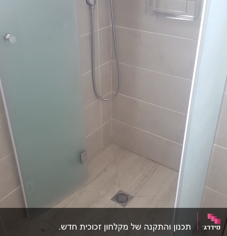 מקלחת עם ראש טוש, דלת זכוכית ומדף מתכת